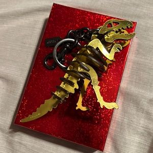 Coach Rexy puzzle dinosaur T. rex fob keychain gold skeleton